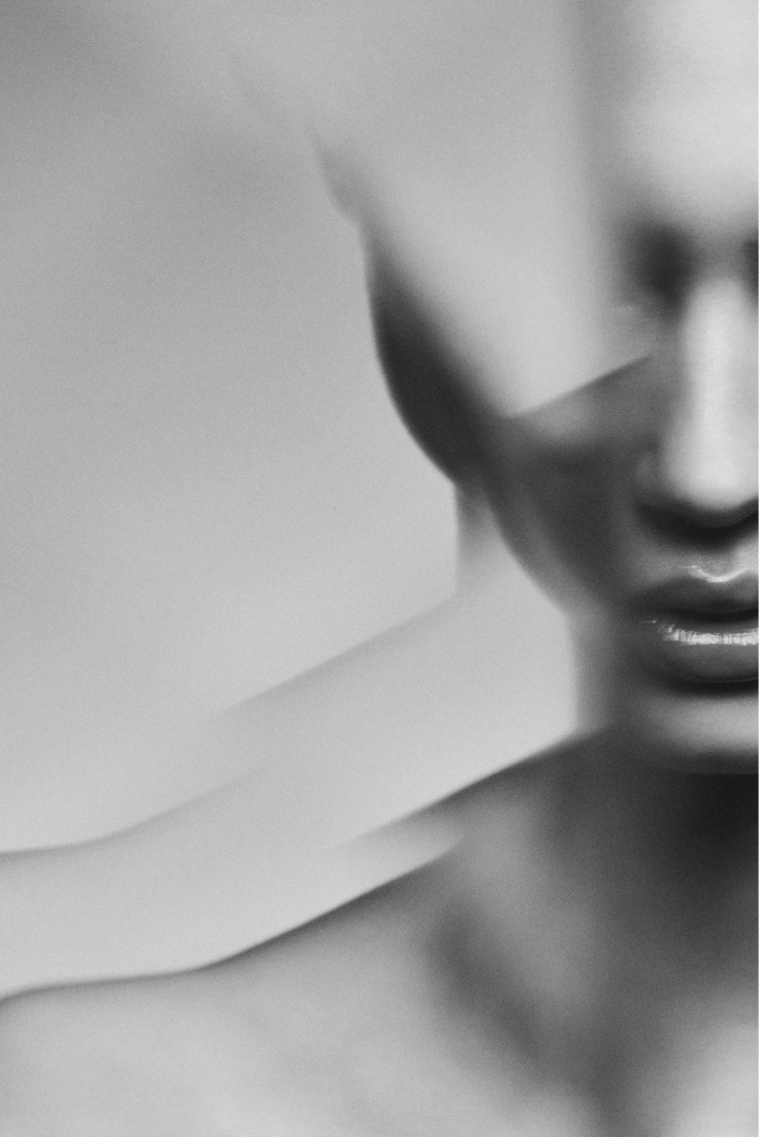 A close-up portrait partly obscured by soft folded fabric