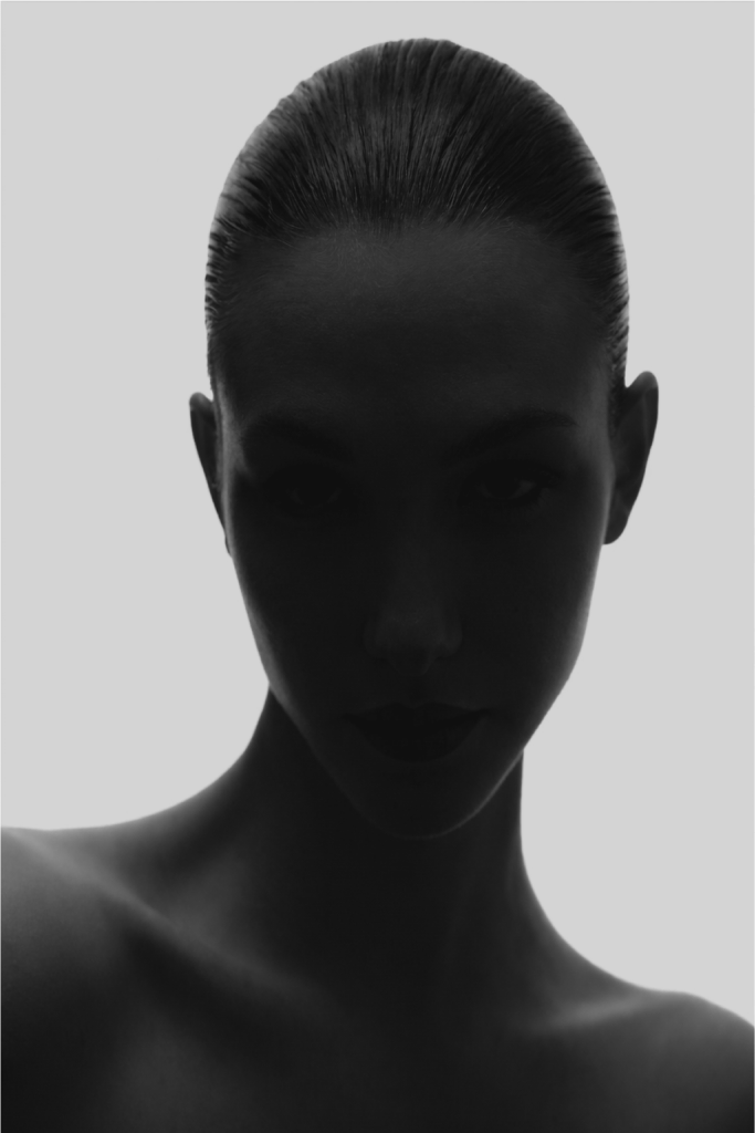 A close-up portrait partly obscured by soft folded fabric