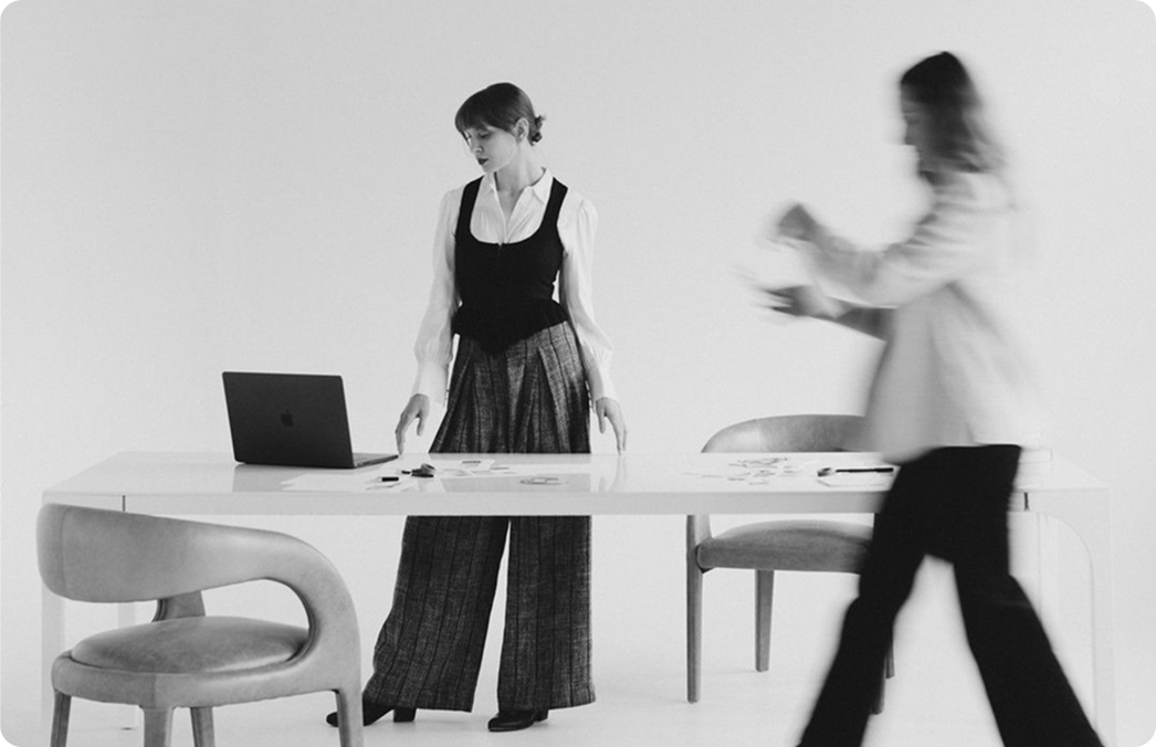 Two people working at a desk in a bright studio space